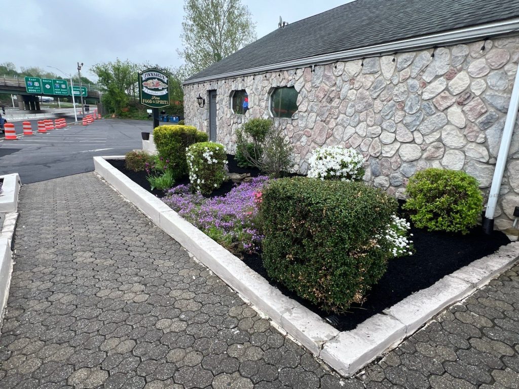 Mulch and flower bed maintenance by Hill Landscaping at a commercial site in Flemington